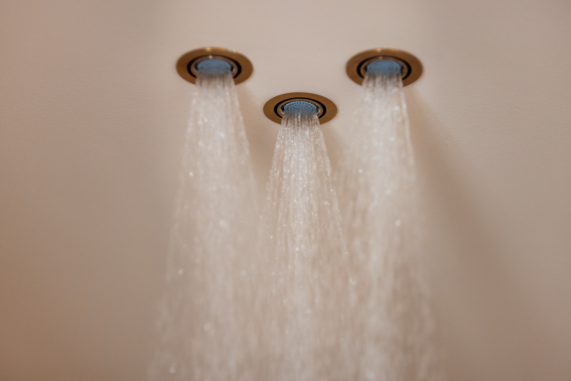 Dettaglio dei tre soffioni doccia Fima Waterdot a soffitto in finitura bronzo ambrato